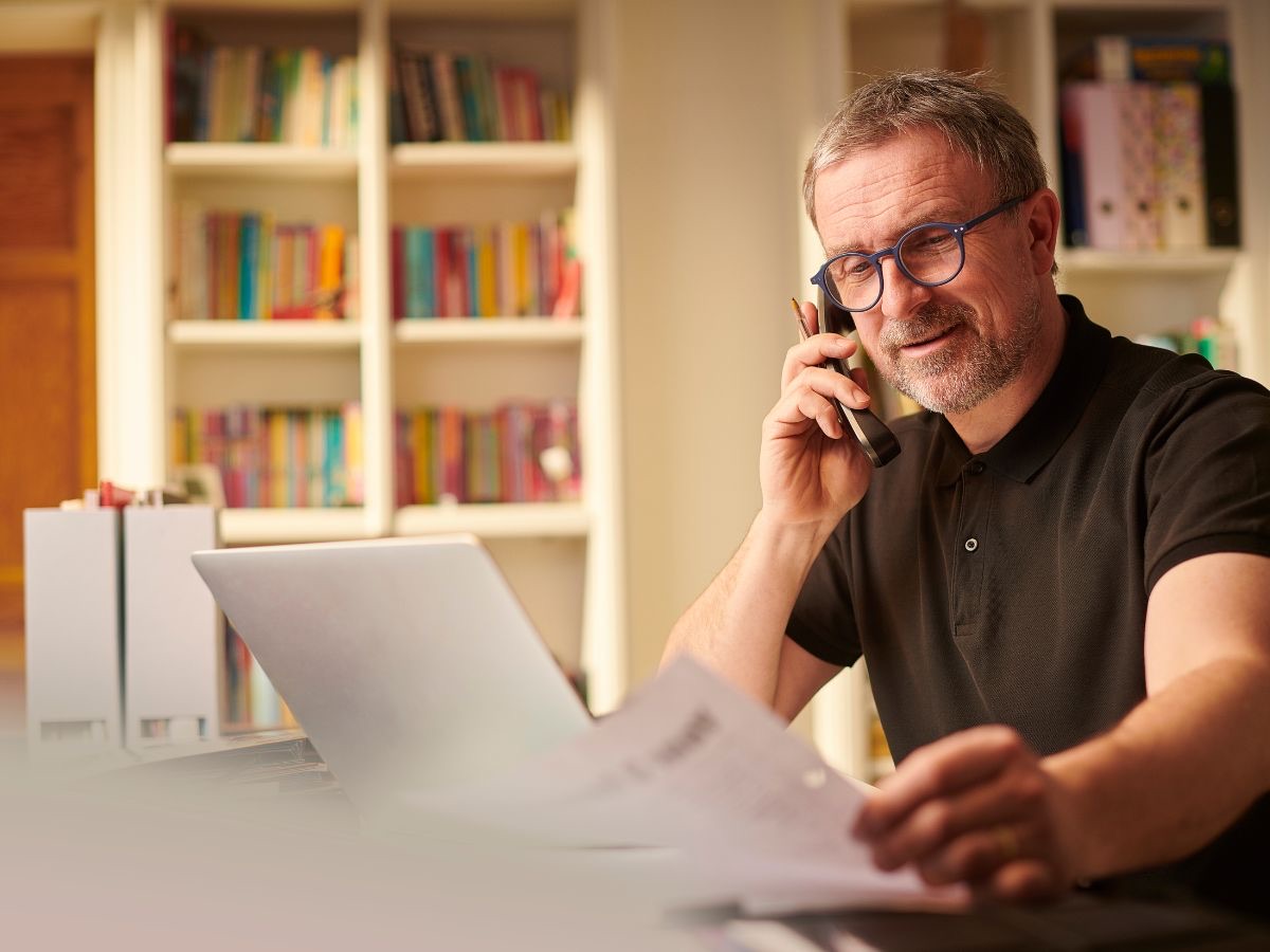 Business owner on the phone reviewing paperwork at his desk