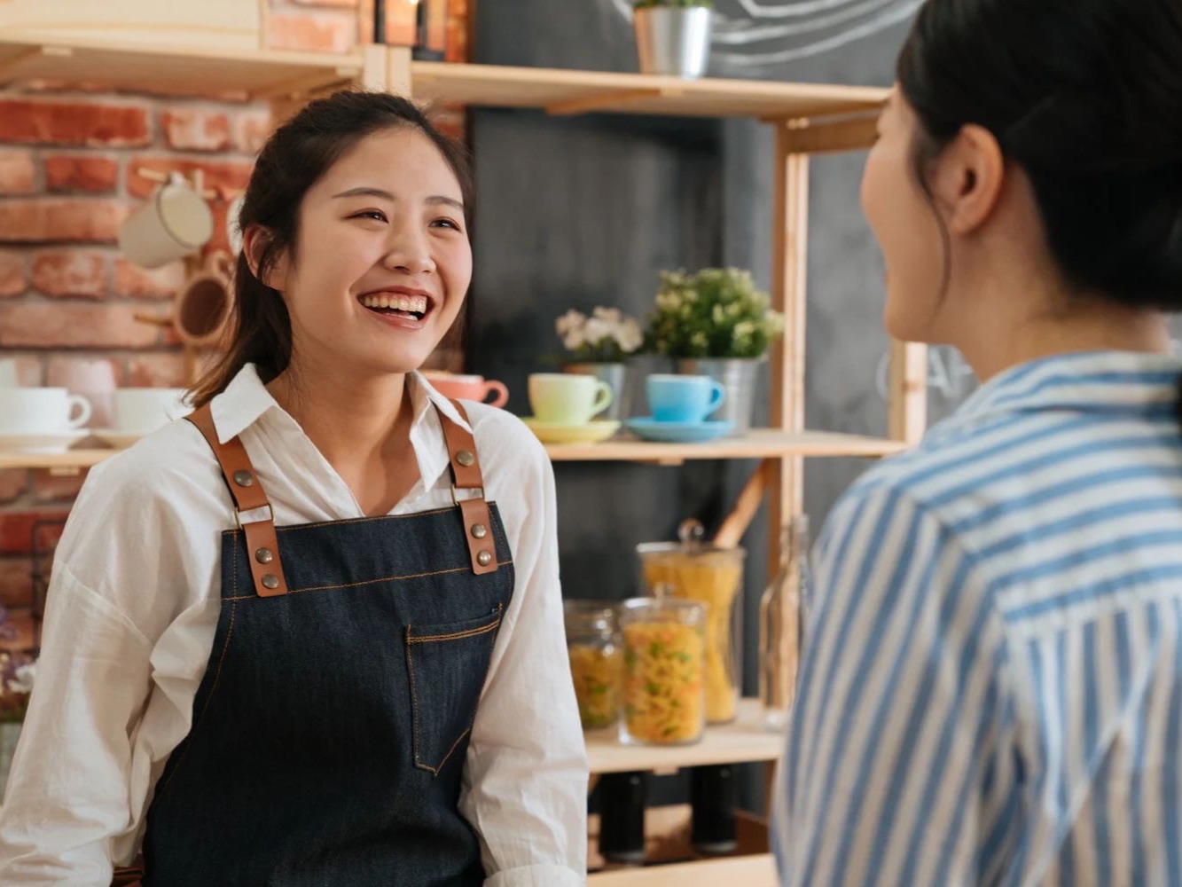 Two people talking across a shop counter